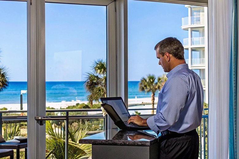 Vacation rental property manager reviewing a booking calendar in a Panama City Beach condo with beach view